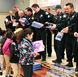 Shop with a Cop & sjshipkits distribute 200+ food kits and  300 Disney themed books